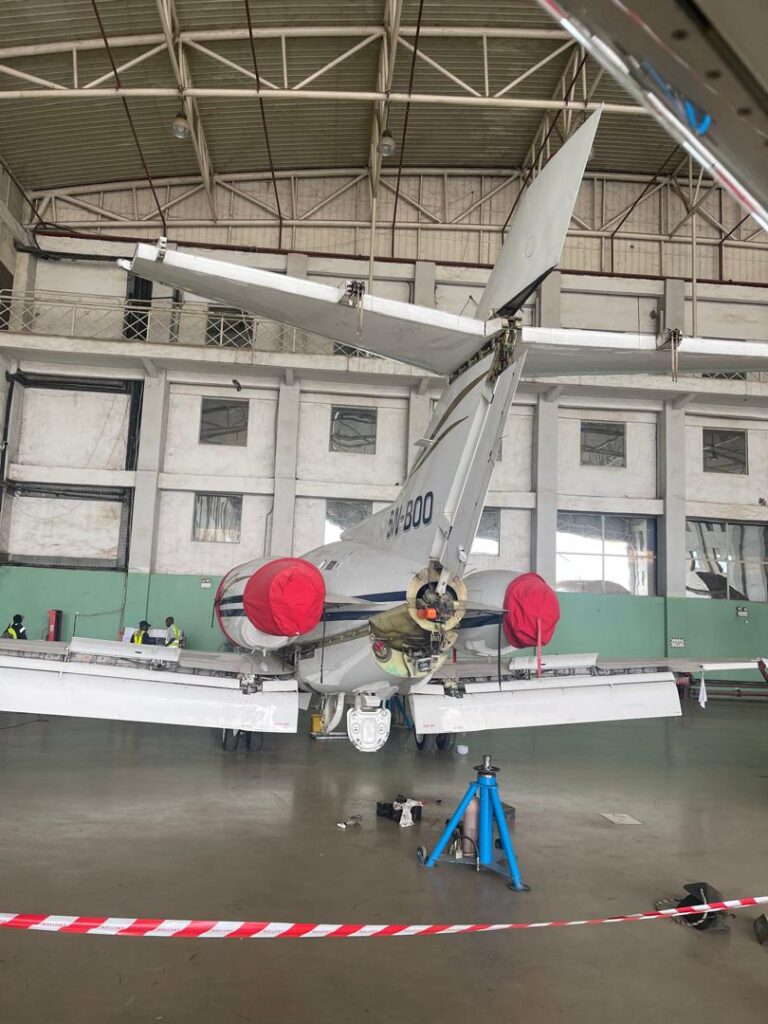 Rear tail and wingspan view of business jet 5N-BOO undergoing maintenance in the DJSD hangar